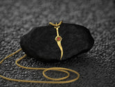Detailed view of synthetic ruby in dagger-shaped pendant.