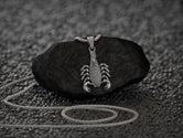 Close-up of armored scorpion pendant, bold gothic style.