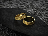 Matching gold wedding bands in woven grid pattern