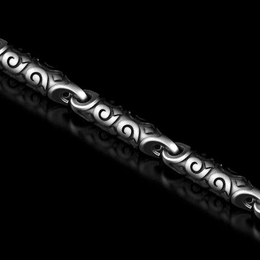 Swirl-pattern chain necklace in oxidized silver on black background