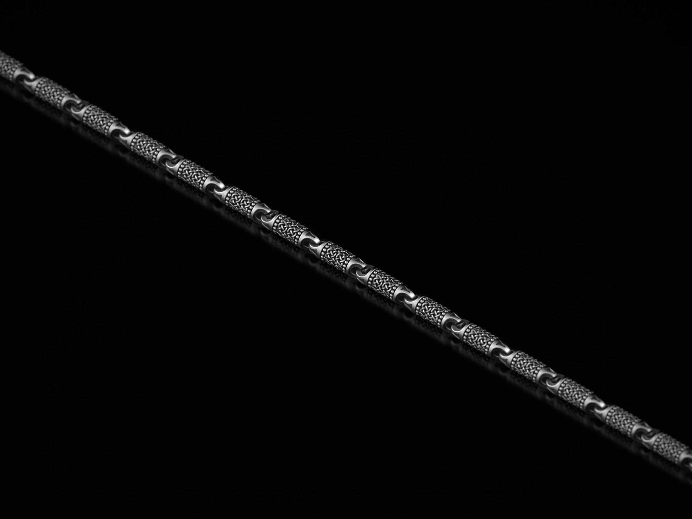 Close-up of Celtic knot pattern on oxidized silver chain