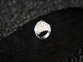 Load image into Gallery viewer, Angled view of polished silver ring on dark stone pedestal.
