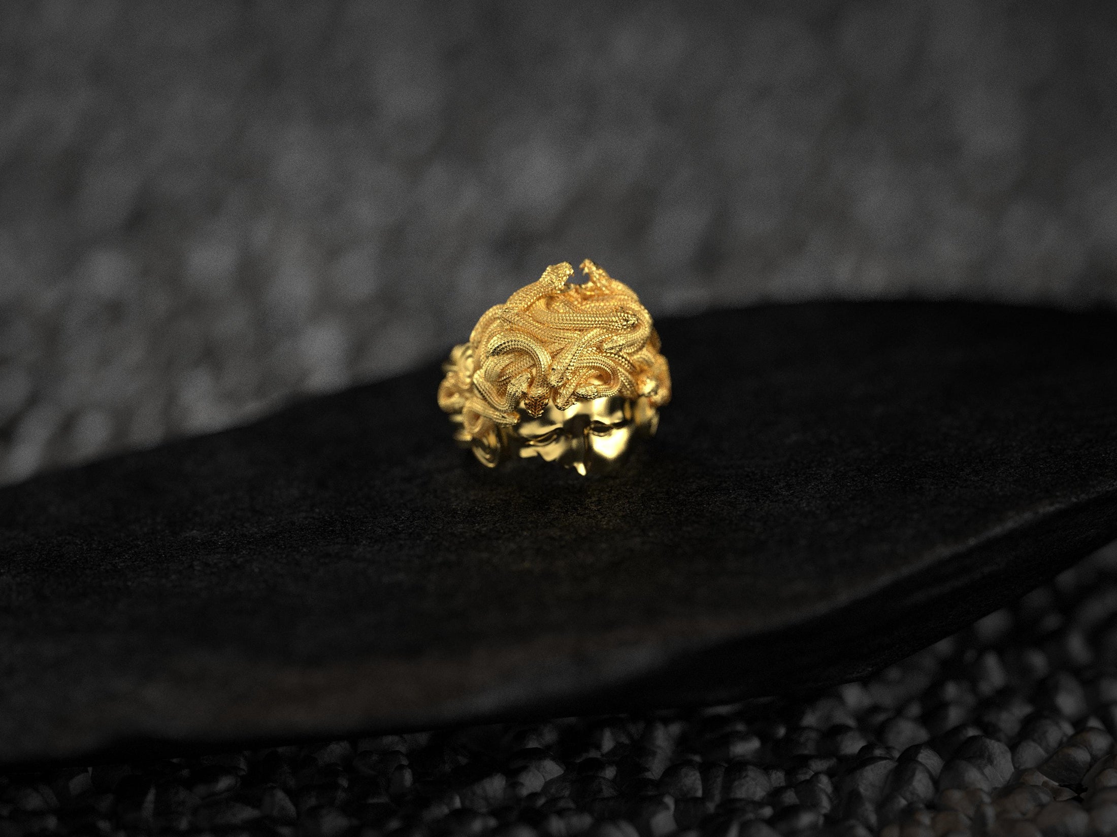 Front view of gold-plated Medusa snake hair detailing.