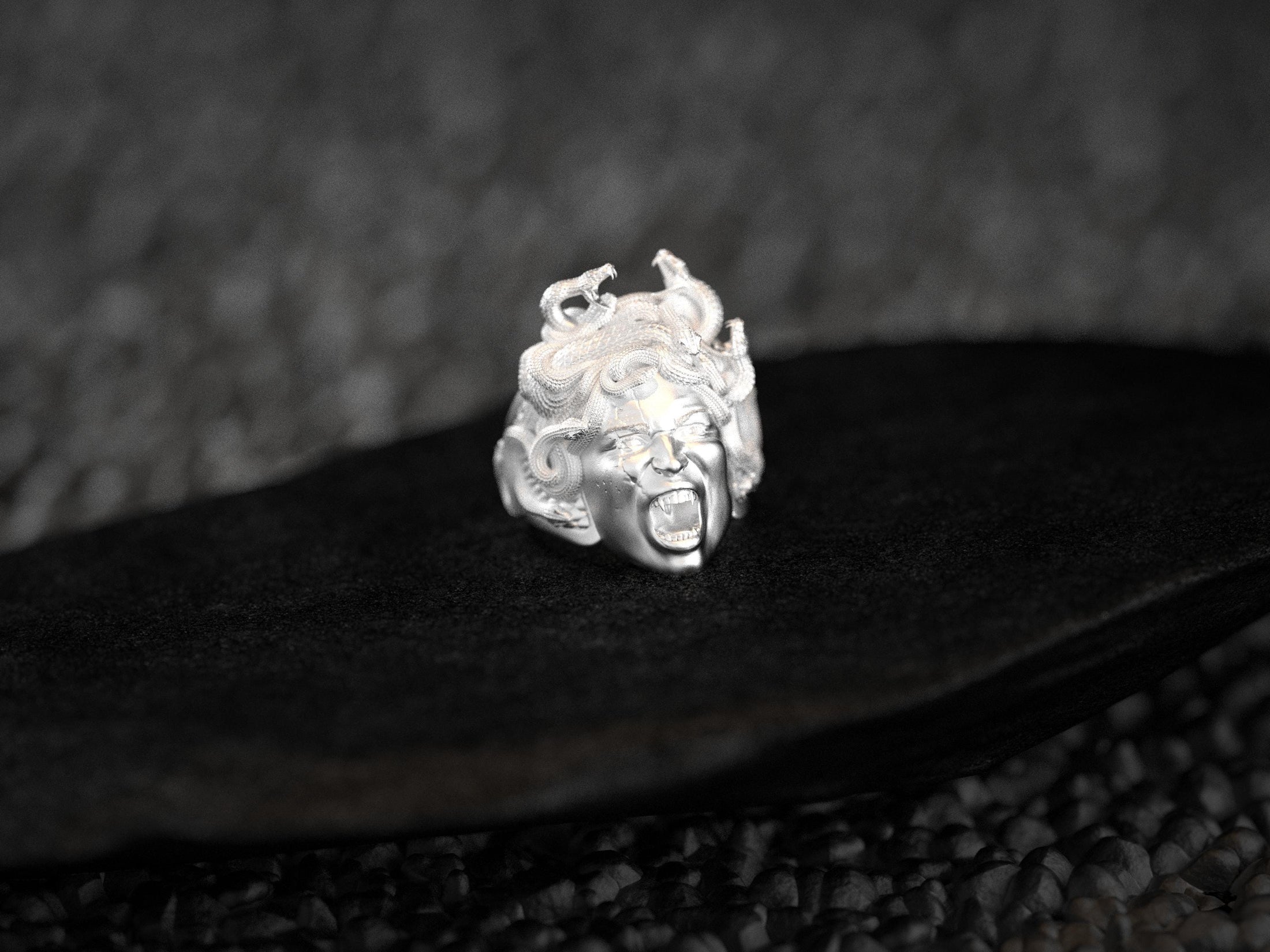 Angled view highlighting serpent hair detail on silver Medusa ring.