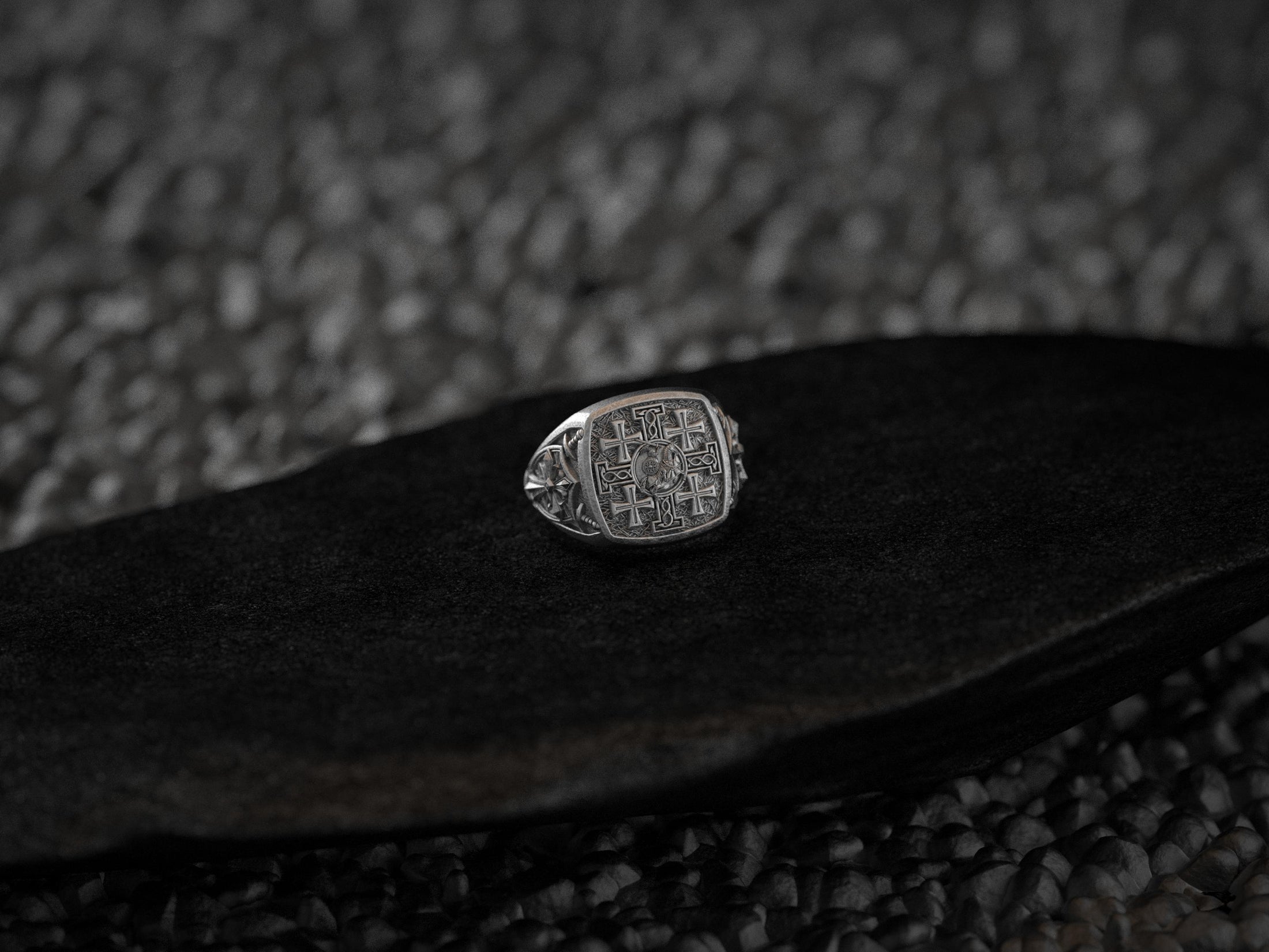 Front-view of the oxidized silver signet ring engraved with the five-cross Jerusalem motif, set on black stone.