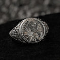 Load image into Gallery viewer, Close-up front view of the polished sterling silver ring face featuring the Good Shepherd cradling a lamb, on black stone.
