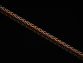 Rose gold-plated Christian link chain on dark surface