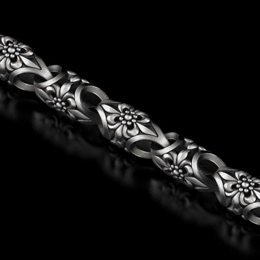 Full view of floral chain bracelet on black background.