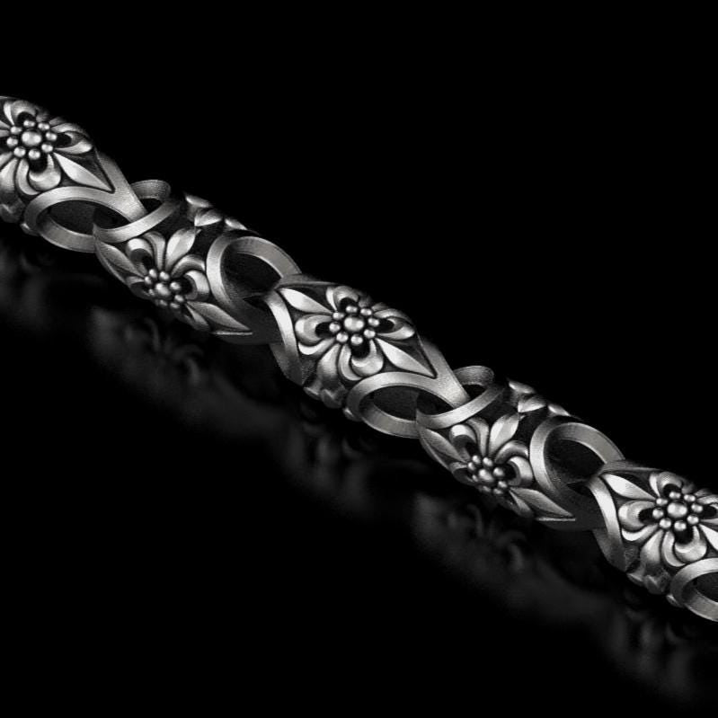 Full view of floral chain bracelet on black background.