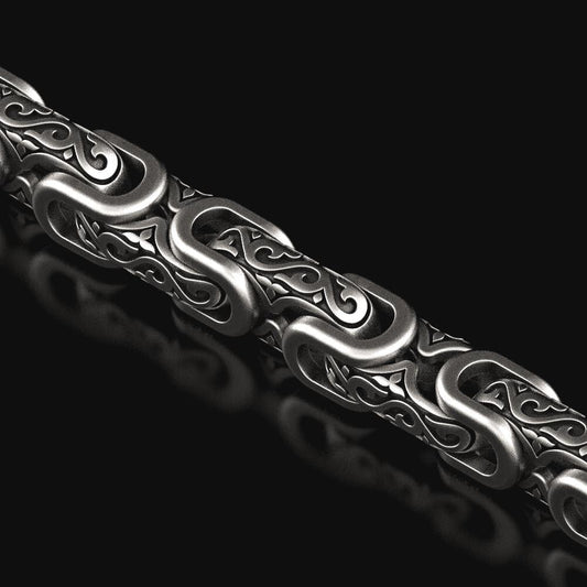 Close-up of oxidized scrollwork chain links with baroque details