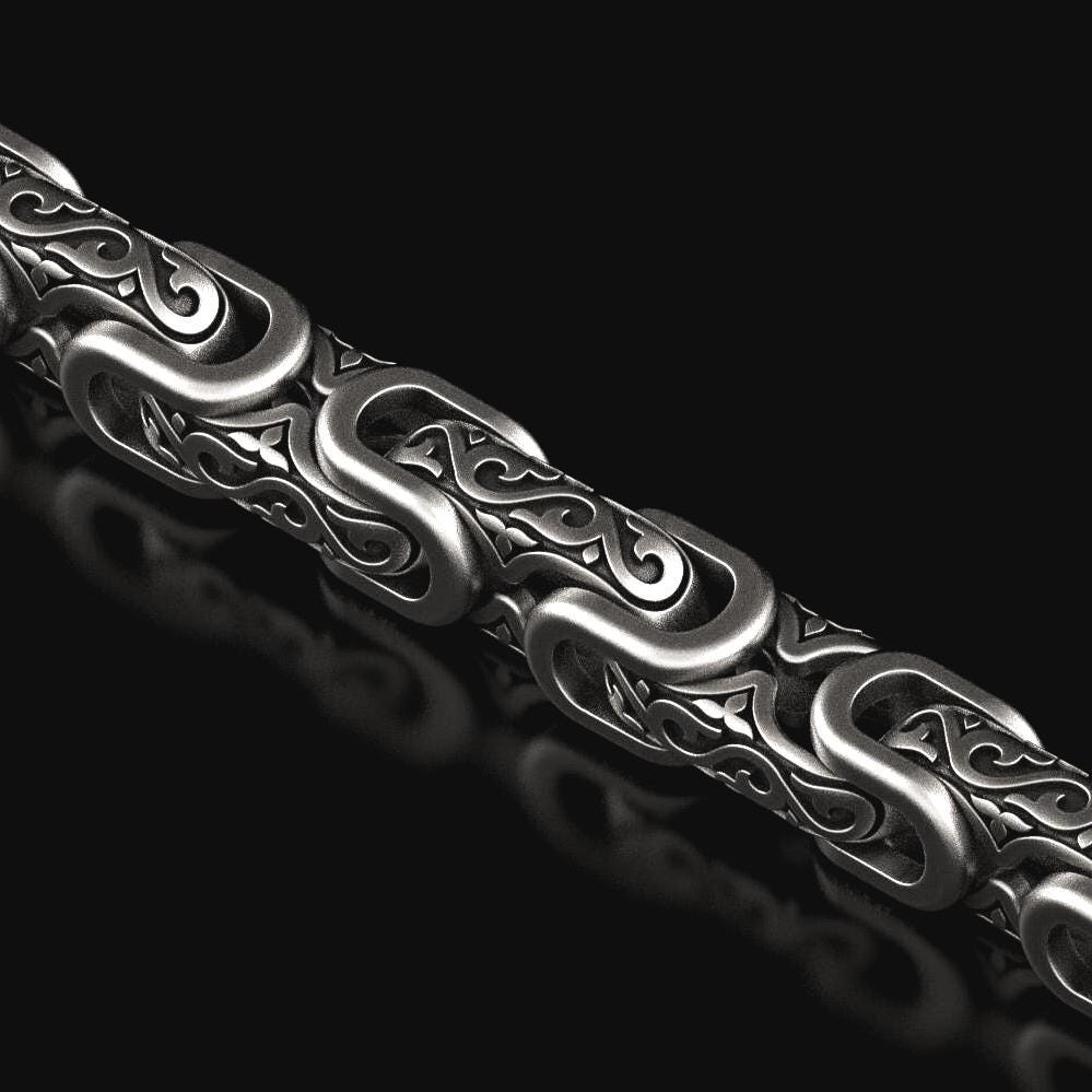 Close-up of oxidized scrollwork chain links with baroque details