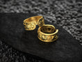 Load image into Gallery viewer, Trio of mythology rings in gold, silver, and rose finishes on textured background
