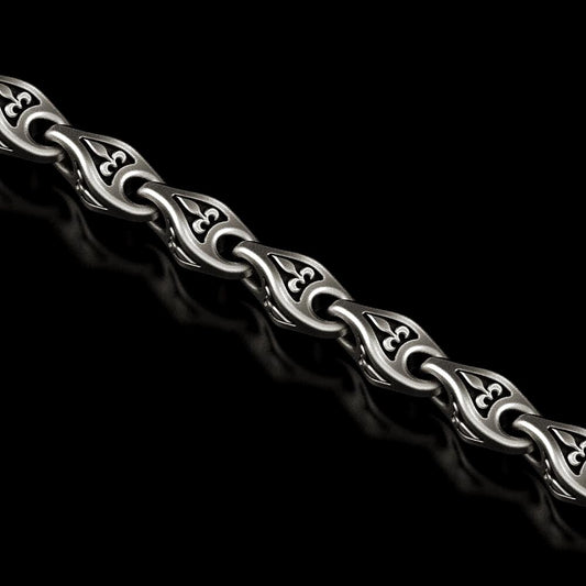 Close-up of oxidized Fleur-de-Lis chain link