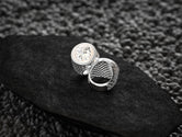 Detailed side texture of round silver men&#39;s crest ring,