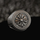 Sterling silver signet ring with fleur-de-lis shield on dark stone,
