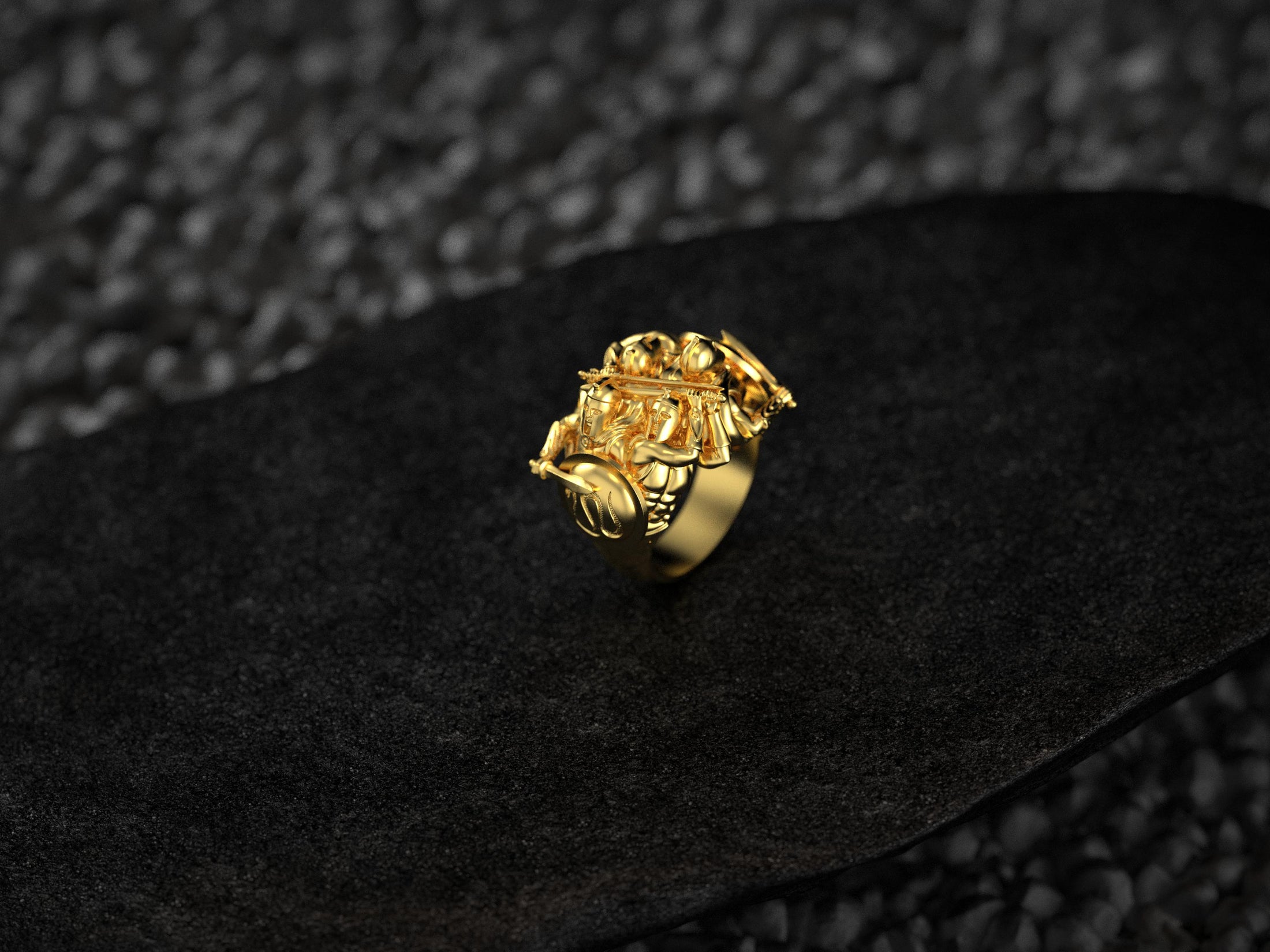 “Gold-plated Spartan warrior trio signet ring on a black slate background, showing intricate hoplite armor and shield detail.”