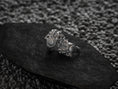 Bild in Galerie-Betrachter laden, “Two matte silver Spartan Phalanx rings from rear view on a black stone slab, revealing interior band hallmarks and shield crests.”
