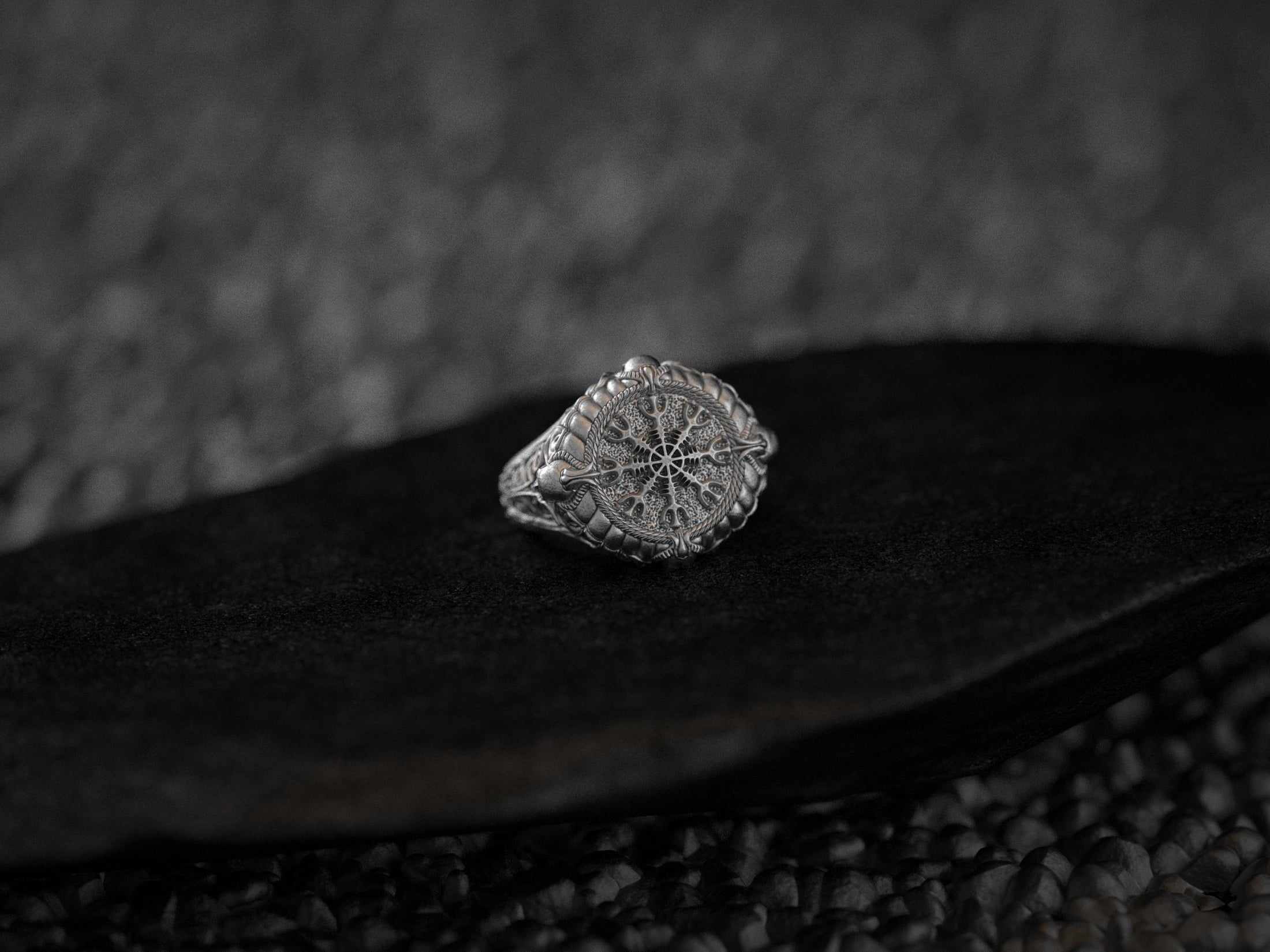 Angled view of silver Viking compass ring highlighting runic detailing.
