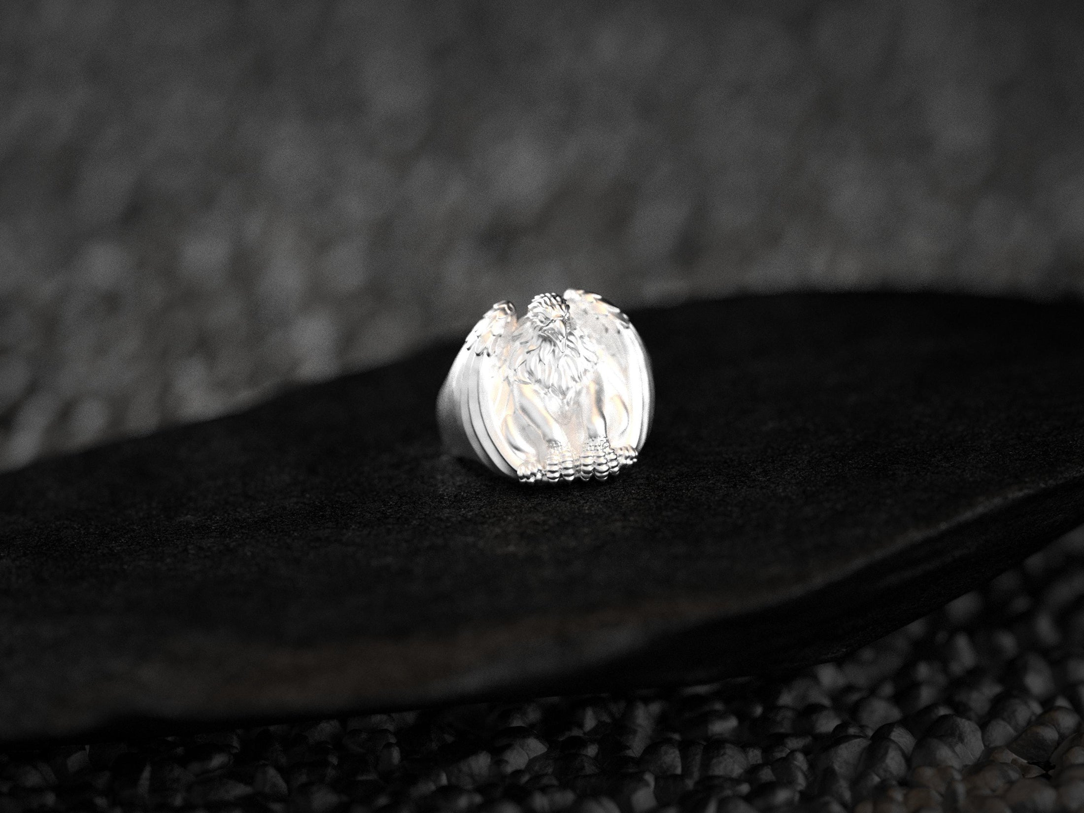 Side view of silver ring band with griffin wing motif.