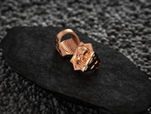 Angled shot of the rose-gold plated ring, illustrating its warm metallic sheen and embossed hexagon shape.