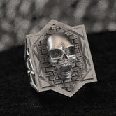 Front-on view of the sterling silver Gothic skull signet ring showing the detailed 3D skull against a brick-patterned hexagon frame.