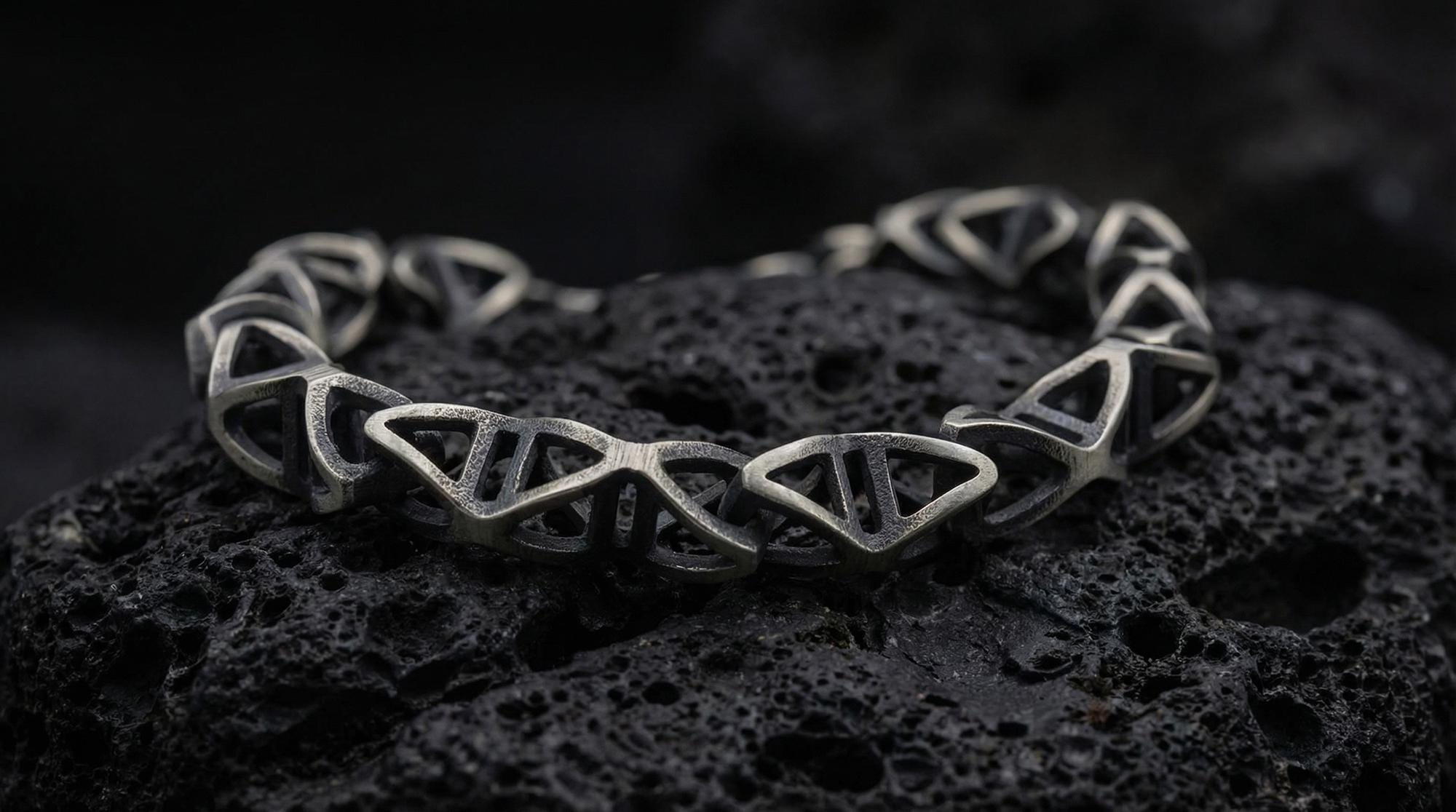 Trigonal DNA Helix bracelet standing on a dark volcanic stone