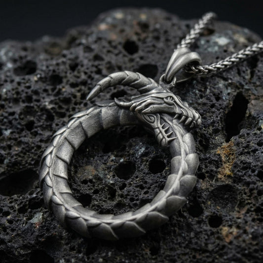 Ouroboros dragon pendant necklace on volcanic stone background