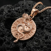 Rose gold plated yin yang dragon medallion necklace with symbolic maze border on volcanic rock surface
