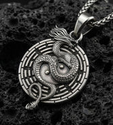 Oxidized yin yang dragon medallion pendant necklace on volcanic rock with detailed mythical dragon engraving
