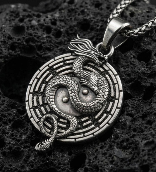 Oxidized yin yang dragon medallion pendant necklace on volcanic rock with detailed mythical dragon engraving