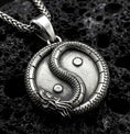 Load image into Gallery viewer, Oxidized yin yang dragon pendant necklace on volcanic rock with detailed oriental medallion design
