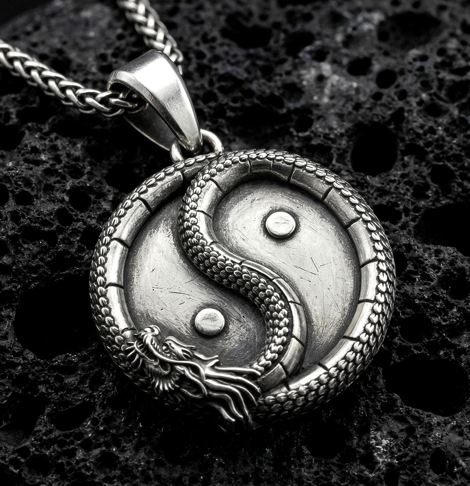 Oxidized yin yang dragon pendant necklace on volcanic rock with detailed oriental medallion design