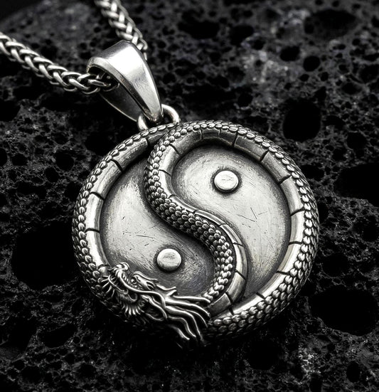 Oxidized yin yang dragon pendant necklace on volcanic rock with detailed oriental medallion design
