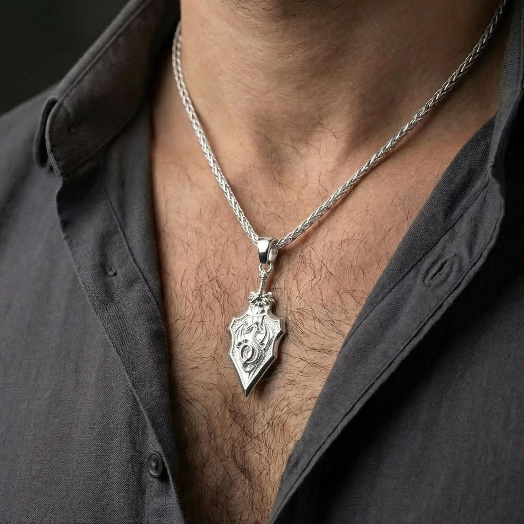 Polished silver dragon crest pendant worn on chest highlighting warrior talisman style