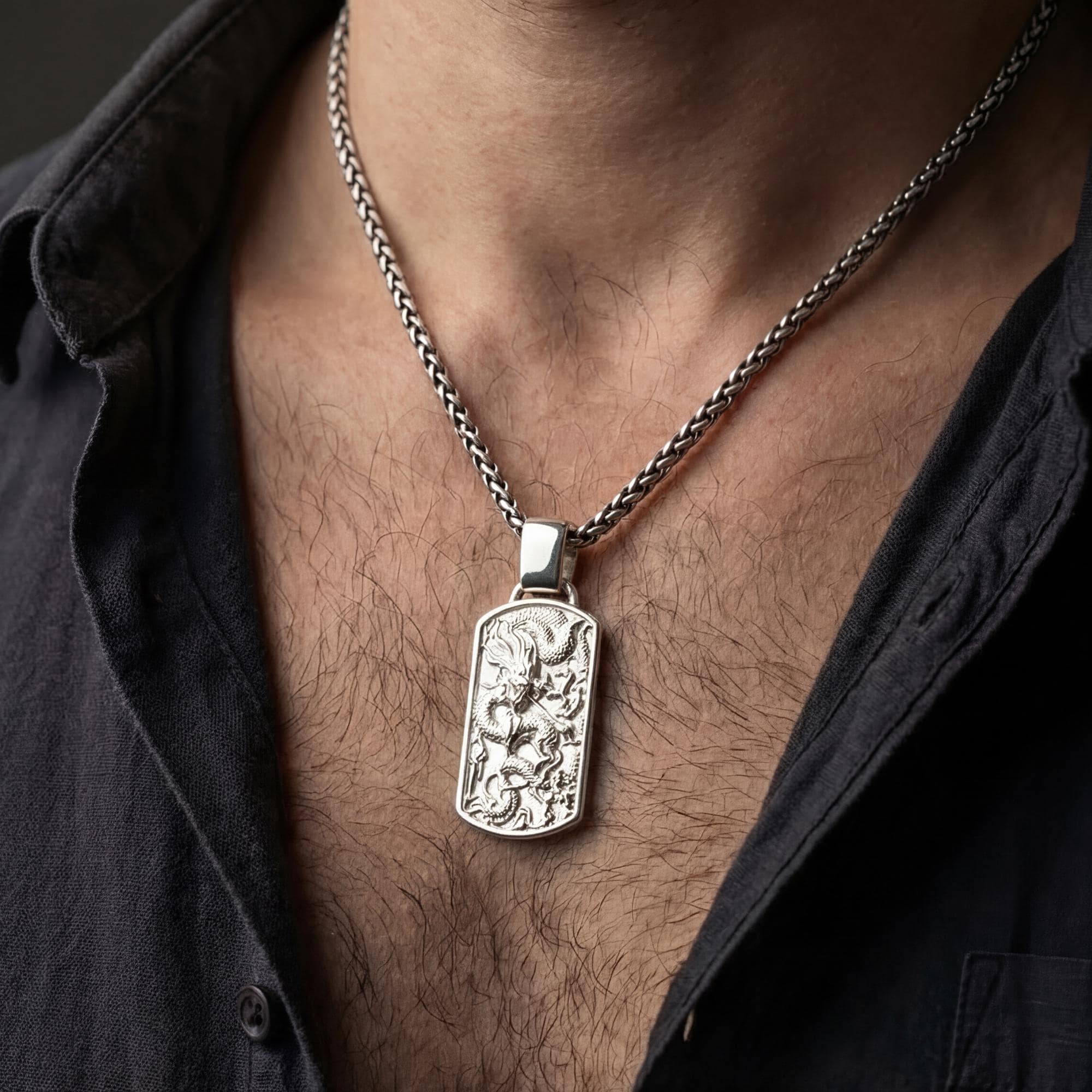 Polished silver dragon dog tag necklace worn on chest highlighting eastern myth symbolism