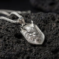 Load image into Gallery viewer, Polished silver oni mask dragon dog tag necklace displayed on volcanic stone background with sharp sculpted relief

