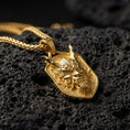 Load image into Gallery viewer, Gold plated oriental demon dragon dog tag pendant showcased on volcanic rock as a symbol of power and protection
