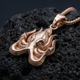Load image into Gallery viewer, Rose gold plated Cthulhu octopus pendant necklace presented on volcanic rock surface with dark cosmic aesthetic

