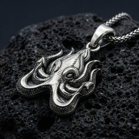 Oxidized Cthulhu octopus pendant necklace photographed on volcanic rock with deep engraved Lovecraftian detail
