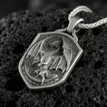 Load image into Gallery viewer, Oxidized fantasy shield dragon pendant necklace photographed on volcanic rock with deep engraved winged dragon detail
