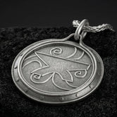 Oxidized Amulet of Zenithar pendant necklace photographed on volcanic rock with engraved Skyrim divine symbol