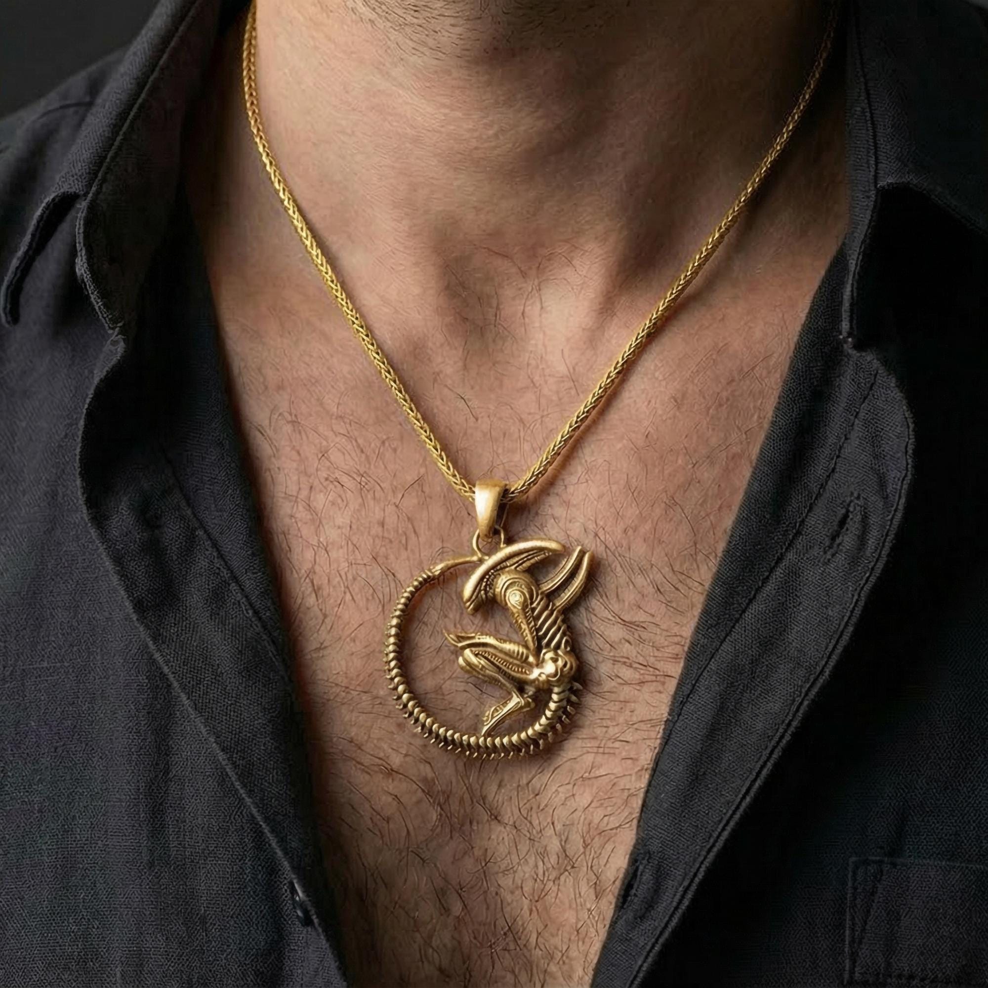 Gold plated alien creature pendant necklace worn by man as bold science fiction statement jewelry