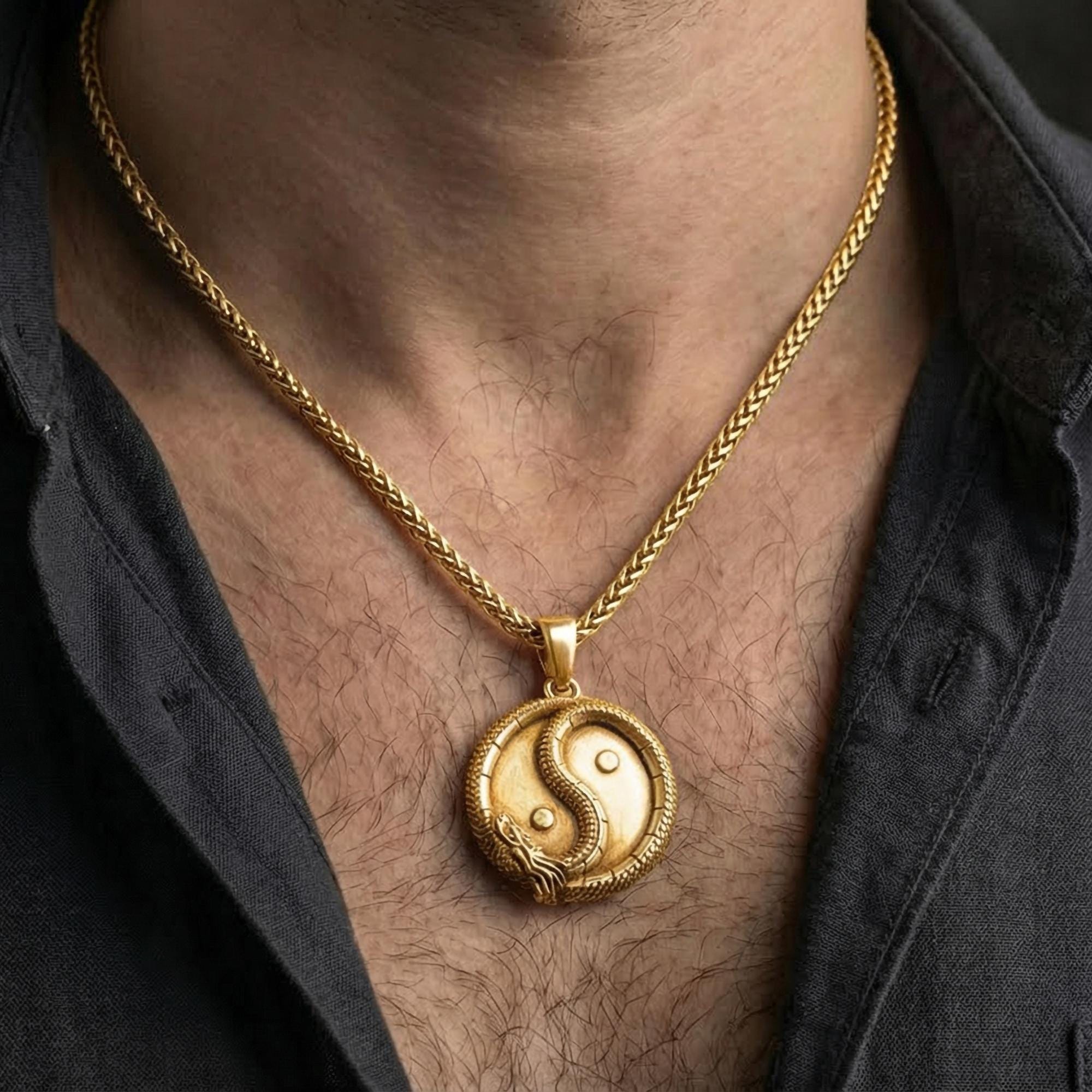 Gold plated yin yang dragon pendant worn by man highlighting oriental harmony symbolism