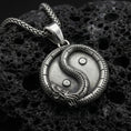 Load image into Gallery viewer, Oxidized yin yang dragon pendant necklace on volcanic rock with detailed oriental medallion design
