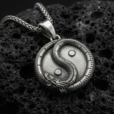 Oxidized yin yang dragon pendant necklace on volcanic rock with detailed oriental medallion design