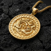 Gold plated dragon and phoenix medallion necklace symbolizing balance on volcanic rock