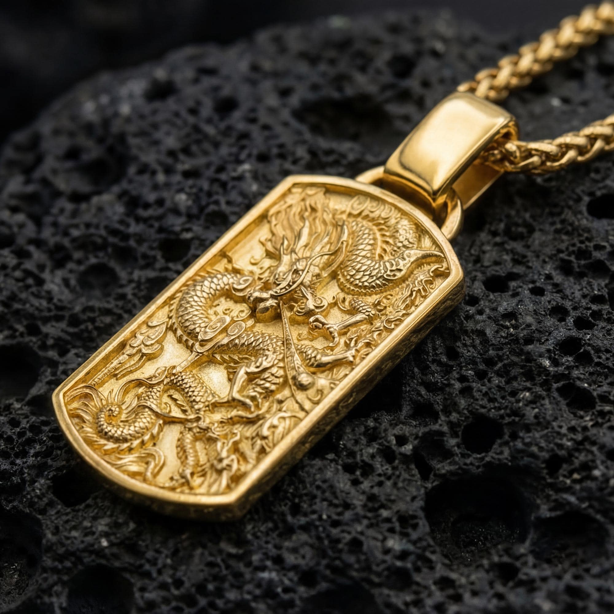 Gold plated eastern dragon dog tag pendant displayed on volcanic rock as power symbol jewelry