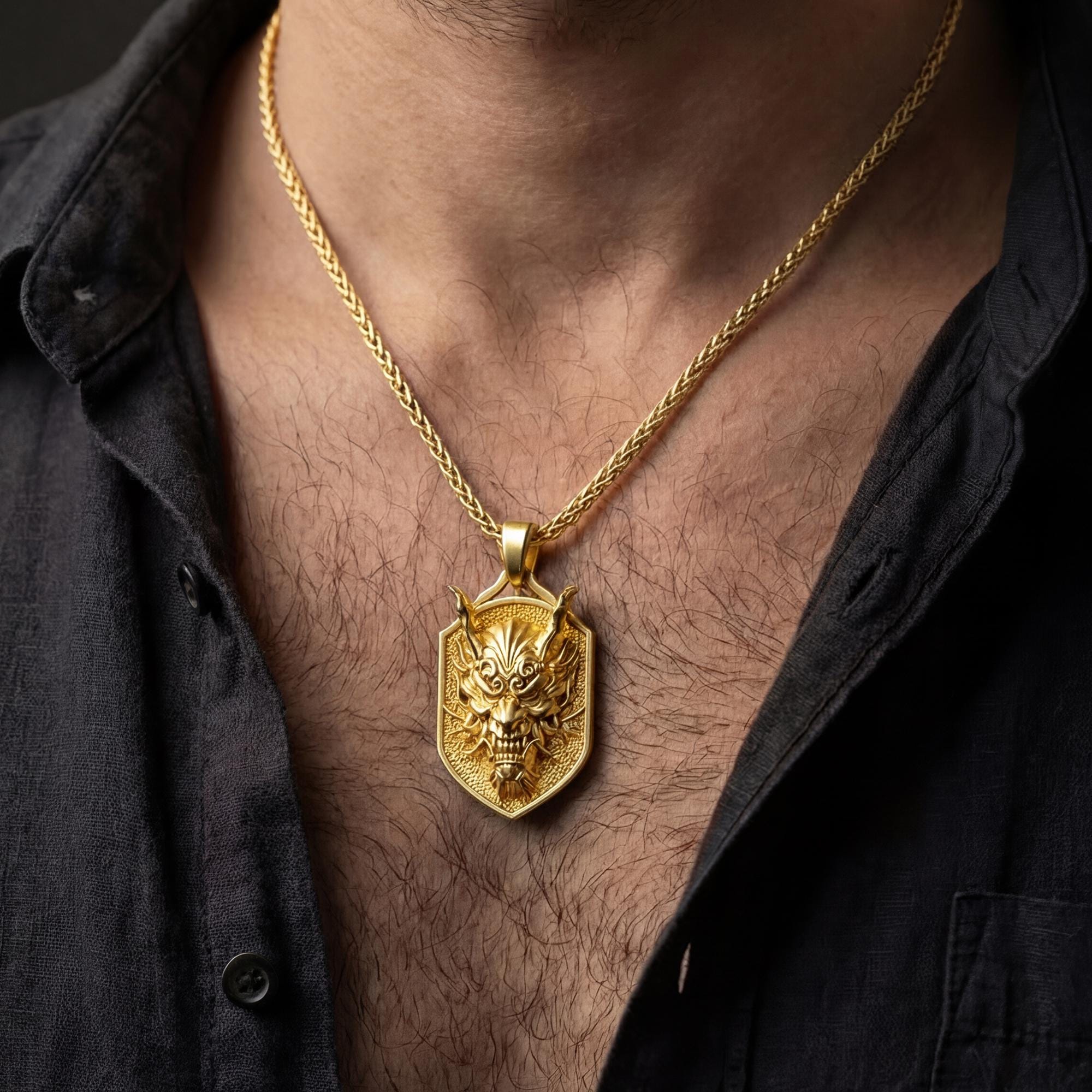 Gold plated oni mask dragon pendant necklace worn by man as bold statement jewelry