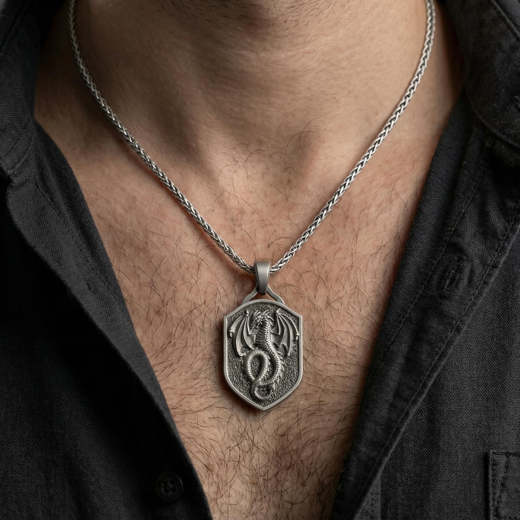 Oxidized coiled dragon shield pendant necklace worn on male model as a guardian talisman