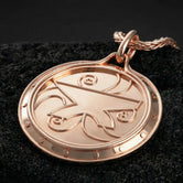 Rose gold plated Skyrim inspired Zenithar amulet presented on volcanic rock surface with refined fantasy aesthetic